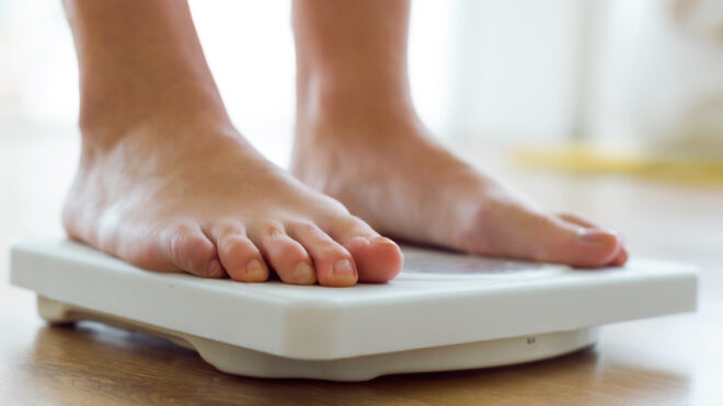 Young healthy girl on home scales.