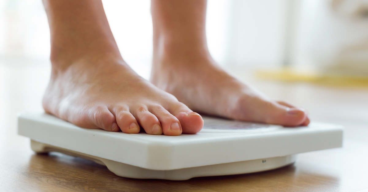 Young healthy girl on home scales.