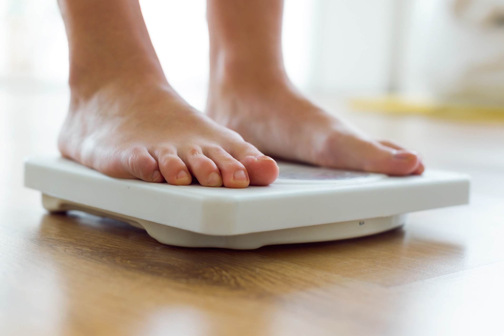 Young healthy girl on home scales.