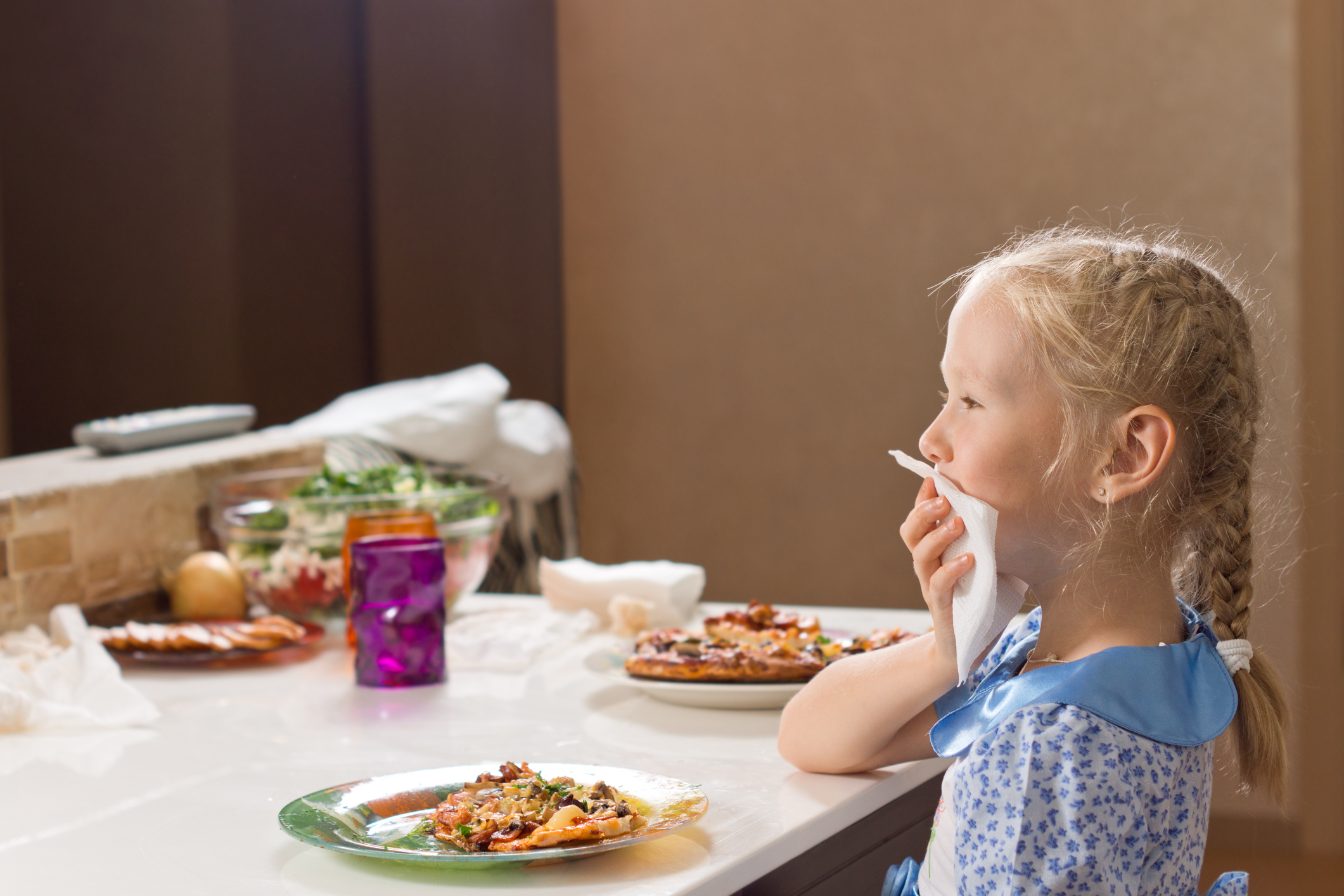 Polite little girl eating homemade pizza