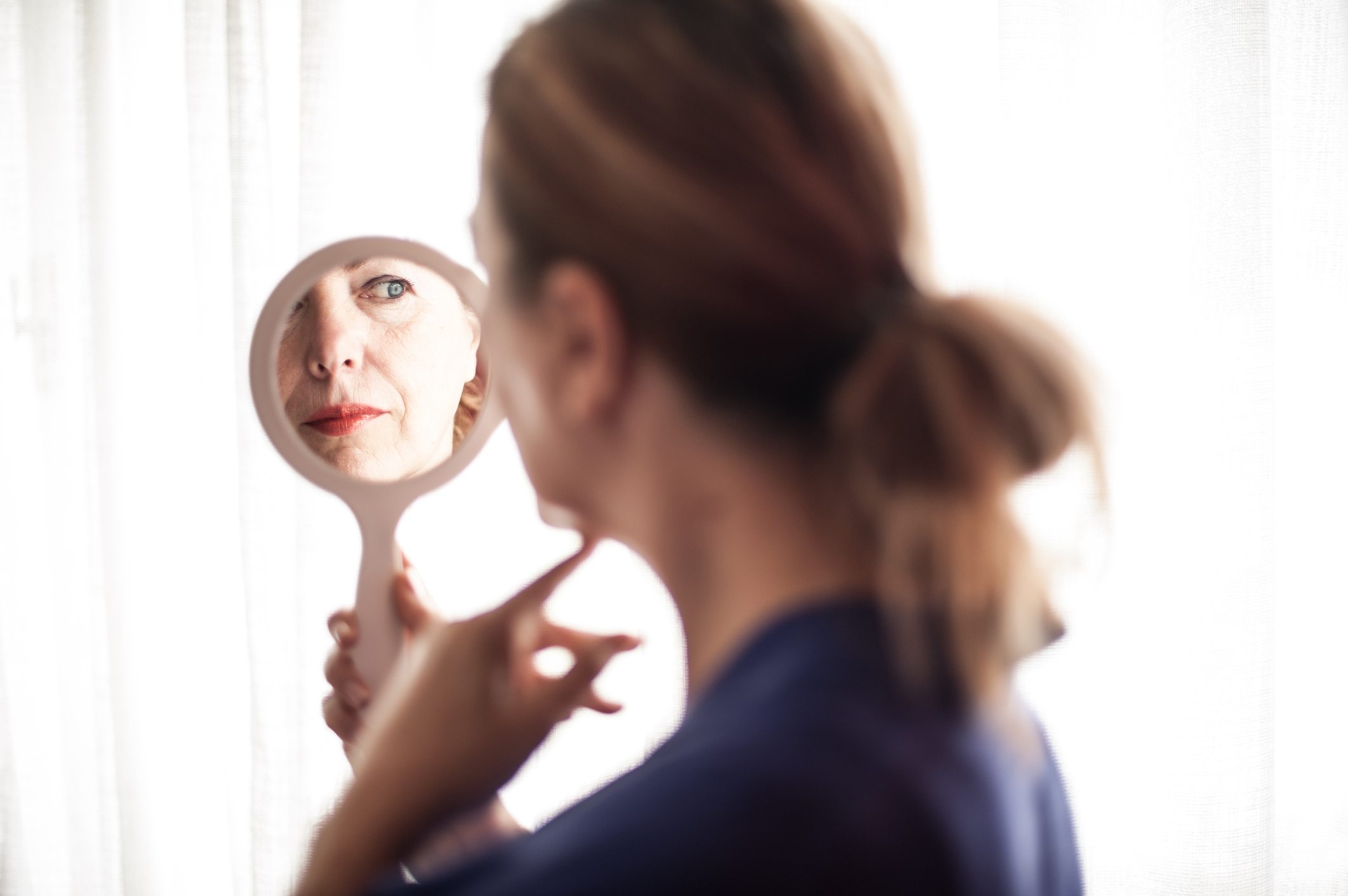 Mirror reflection of mature woman