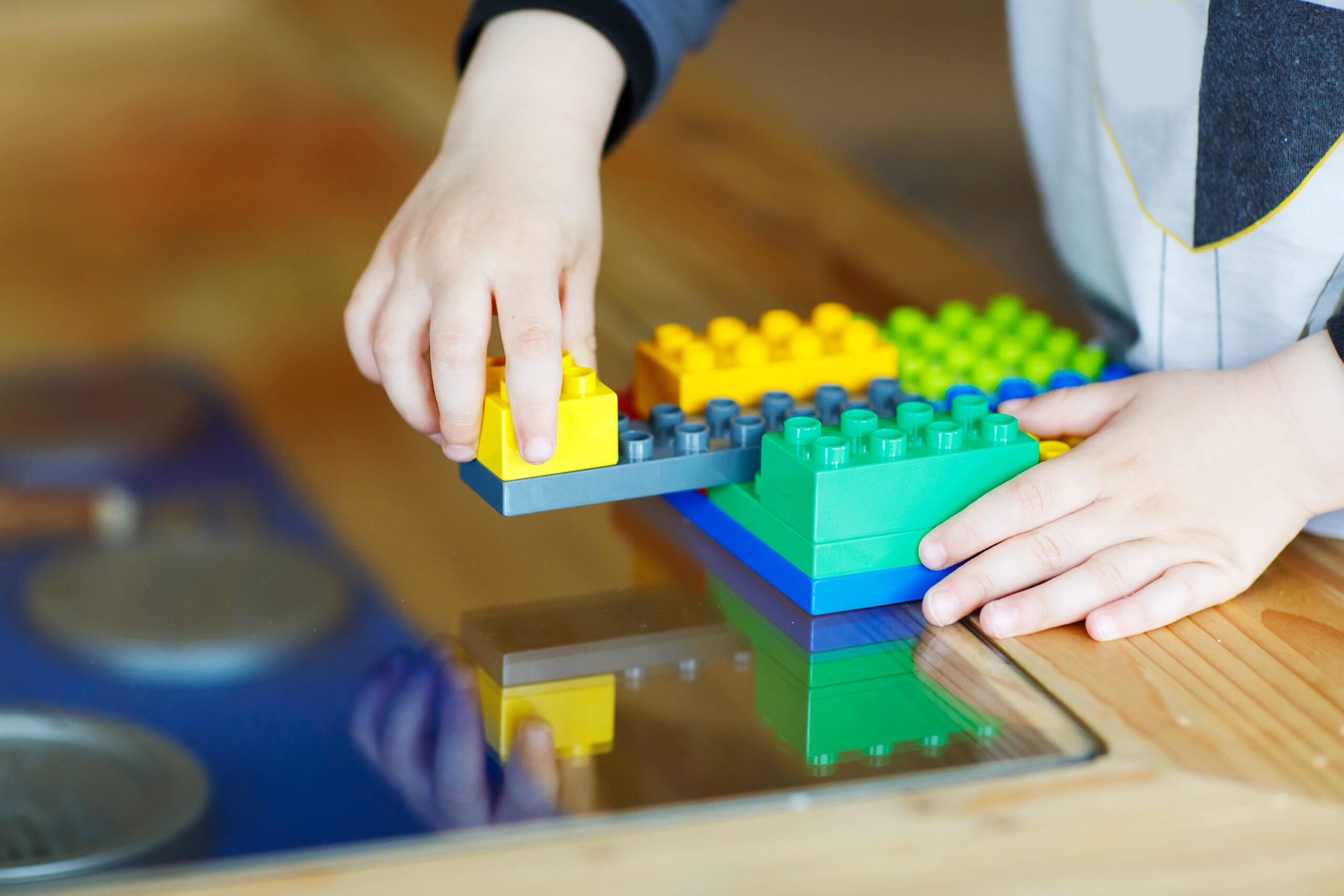 Hand child playing with construction blocks