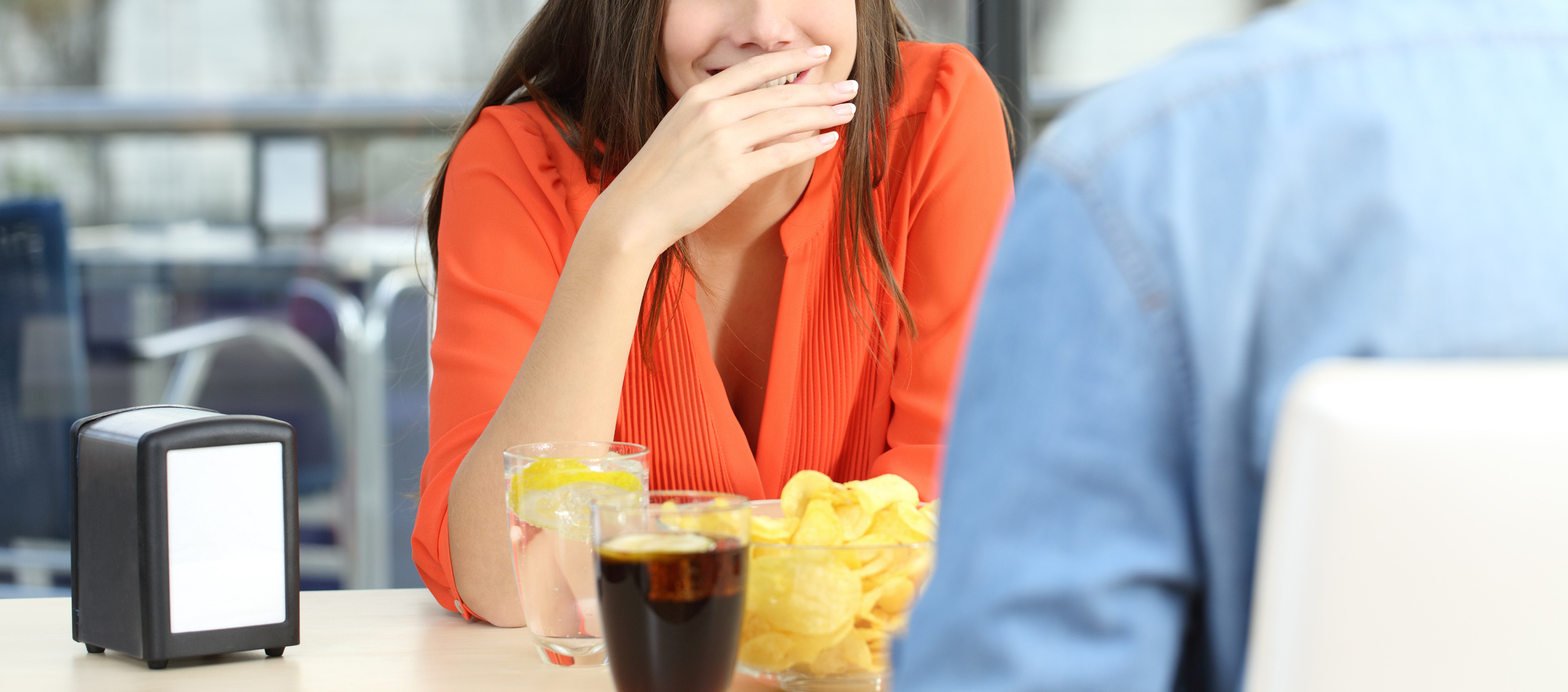 Woman covering her mouth to hide smile or breath