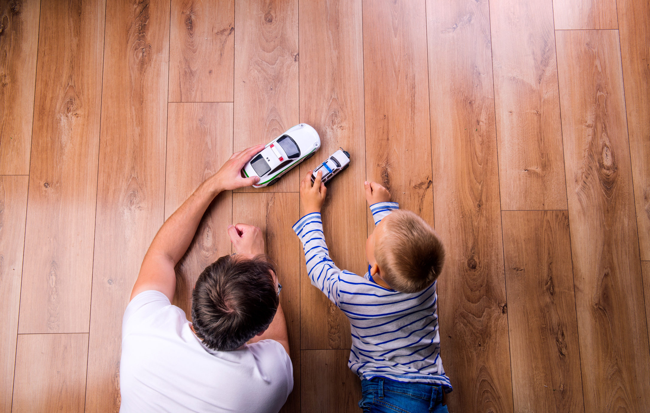 Unrecognizable father with his son playing with cars