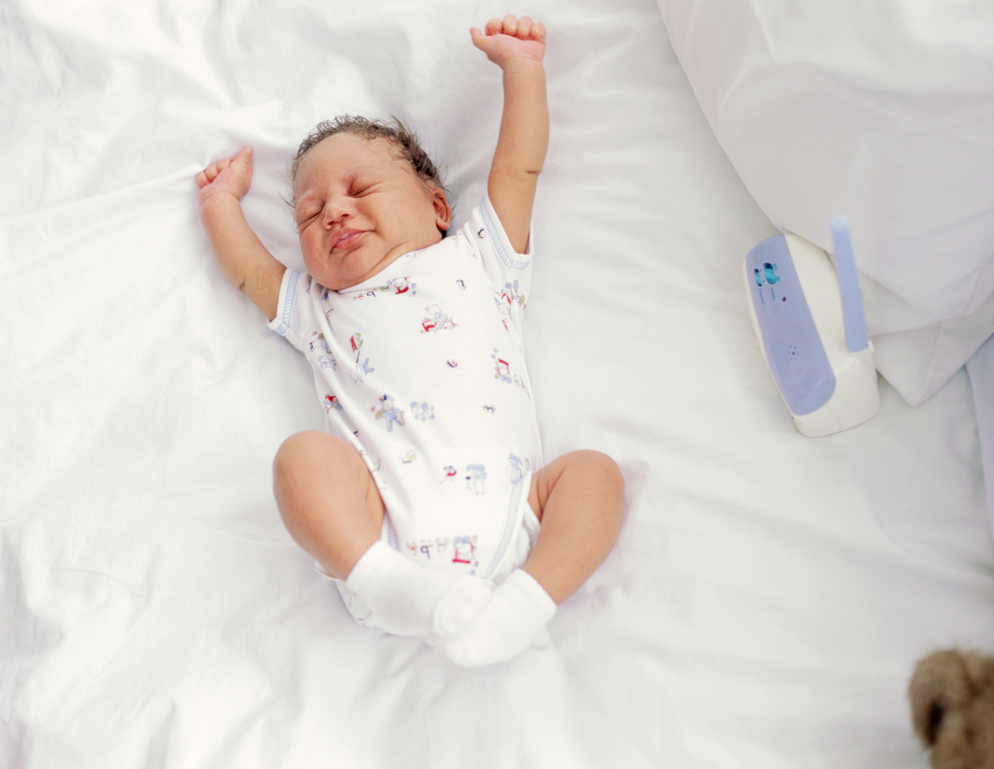 high angle view of a baby stretching on a bed