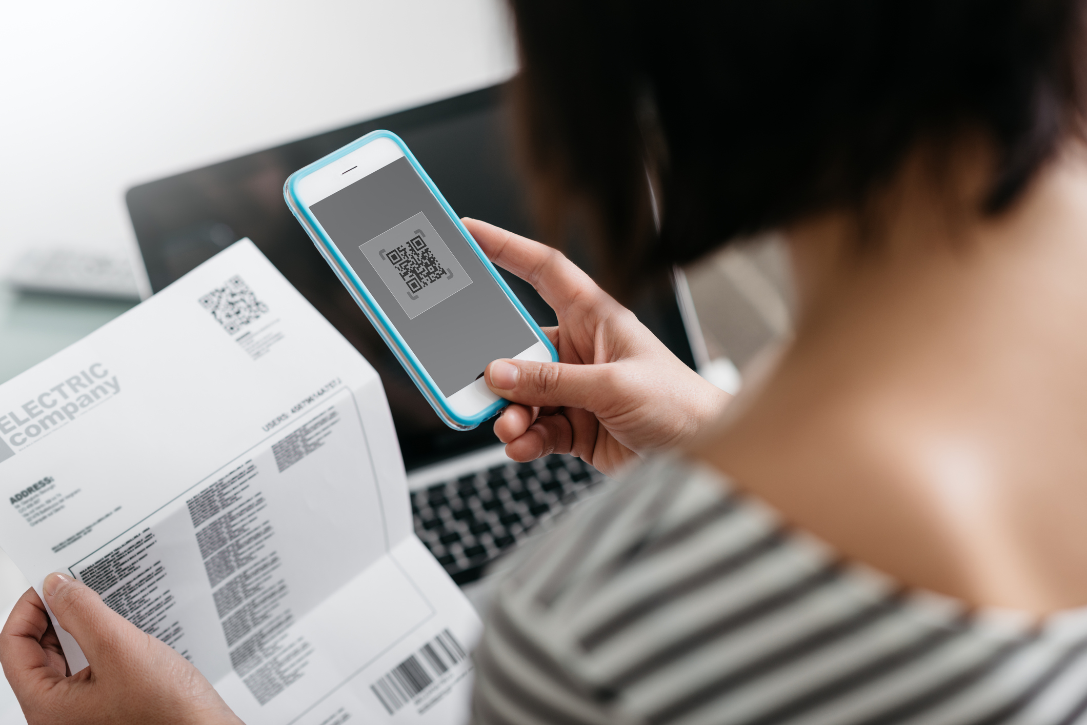 Woman paying bills with her smartphone