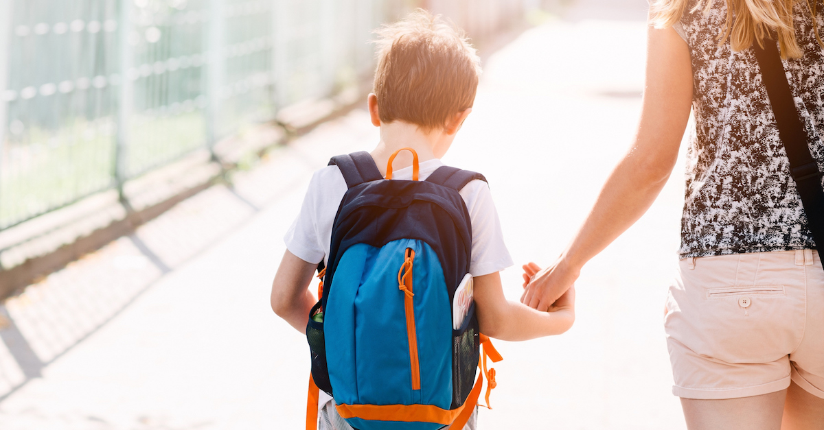 7 years old boy going to school with his mother