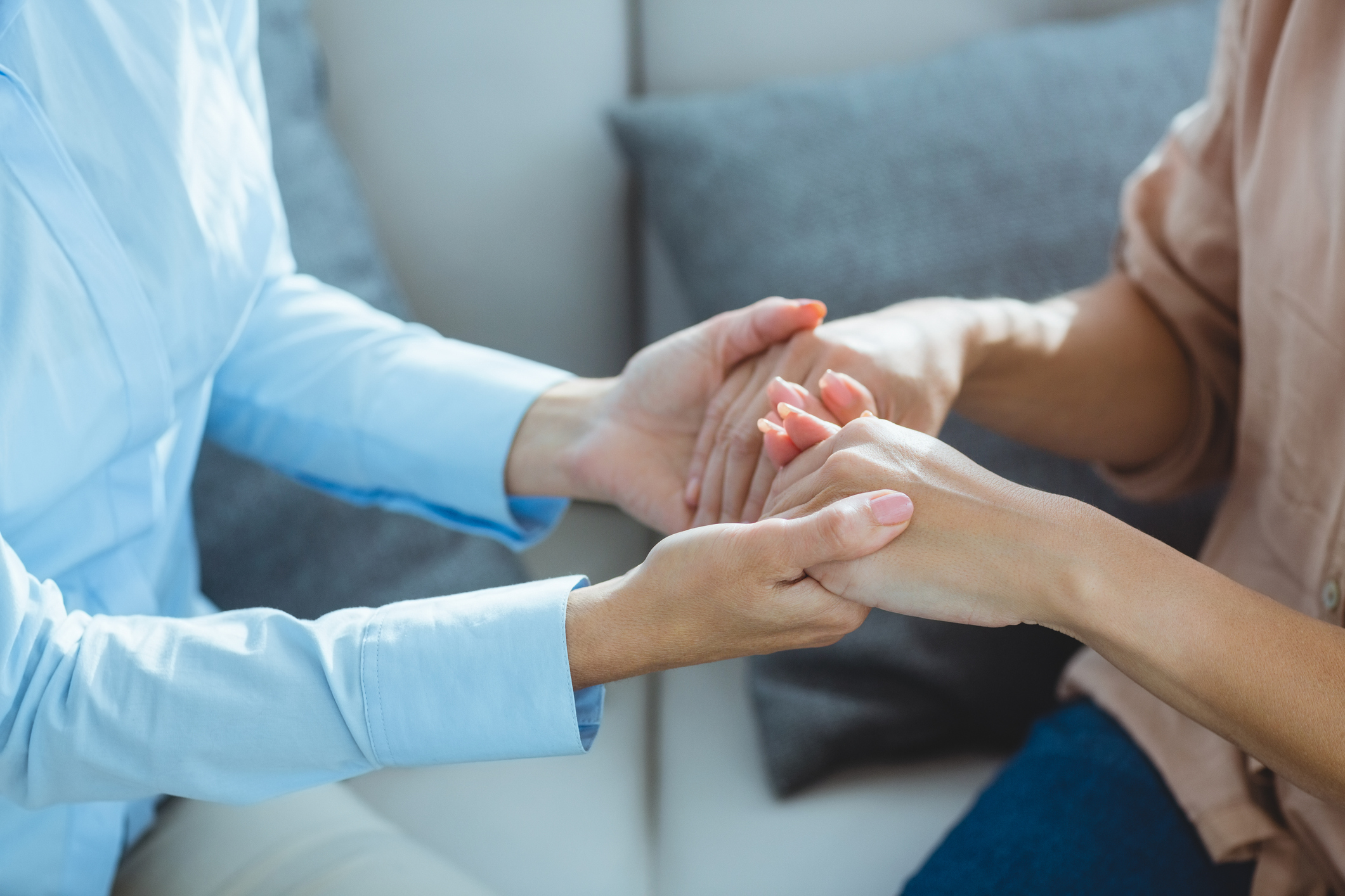 Midsection of therapist holding patient hands