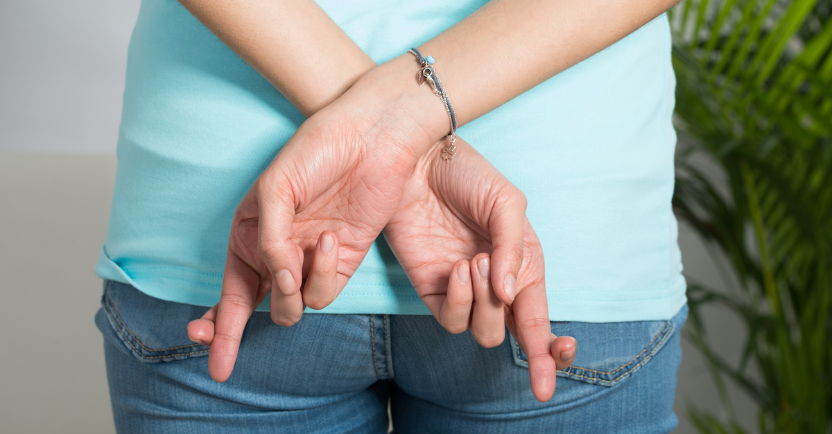 Midsection Of Woman With Fingers Crossed