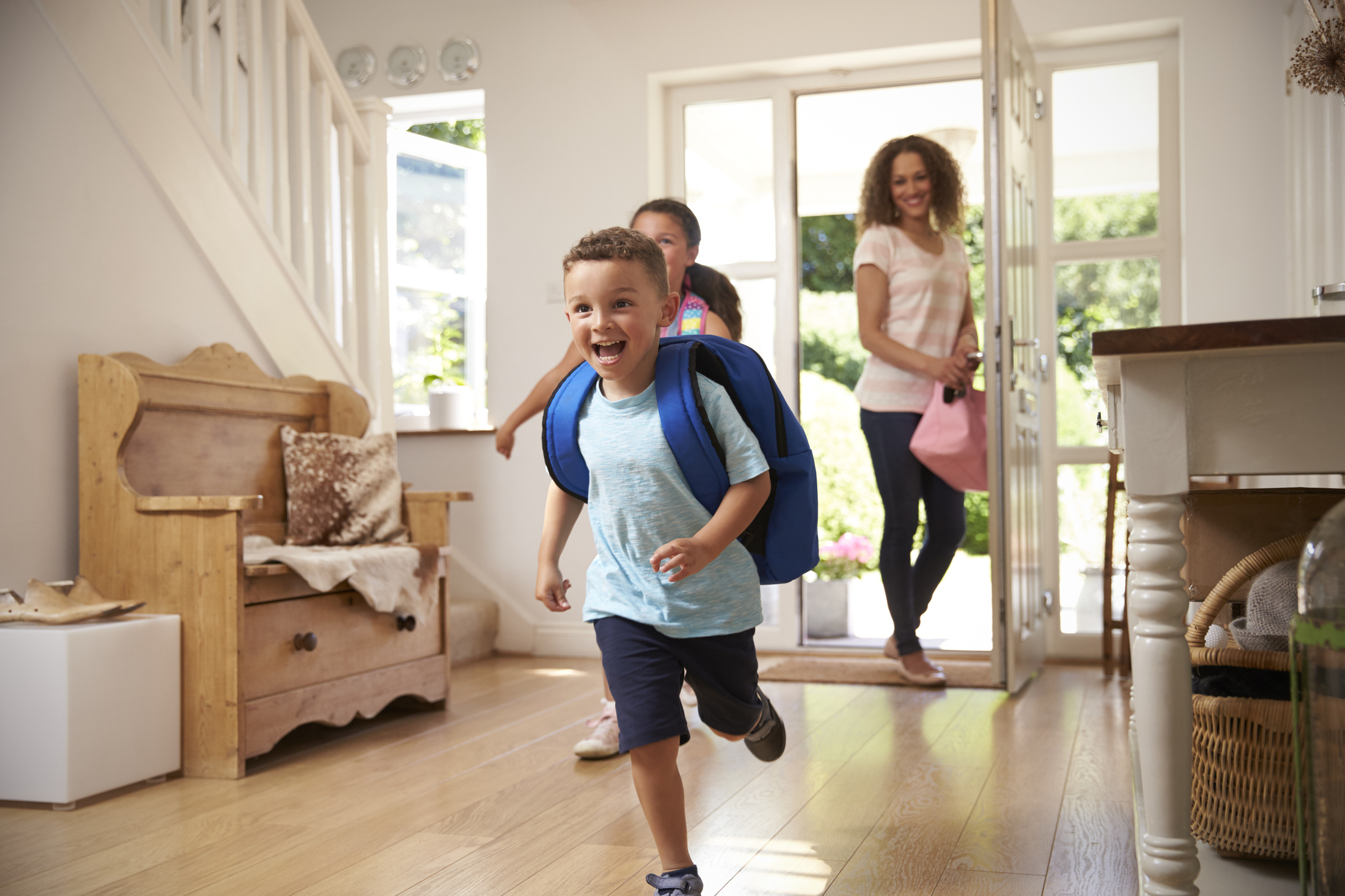 Excited Children Returning Home From School With Mother