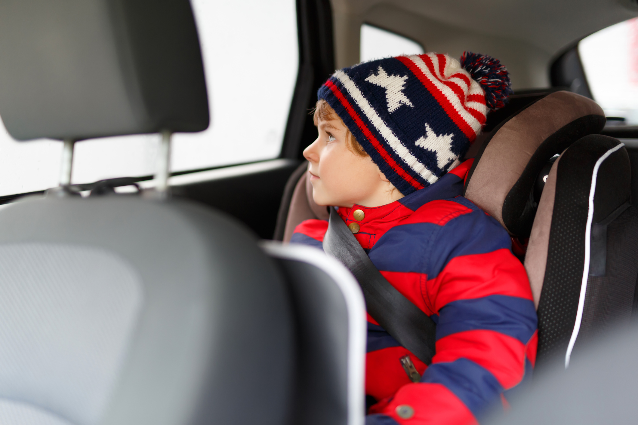 Little kid boy sitting in safety car seat during trip Little kid boy sitting in safety car seat during trip