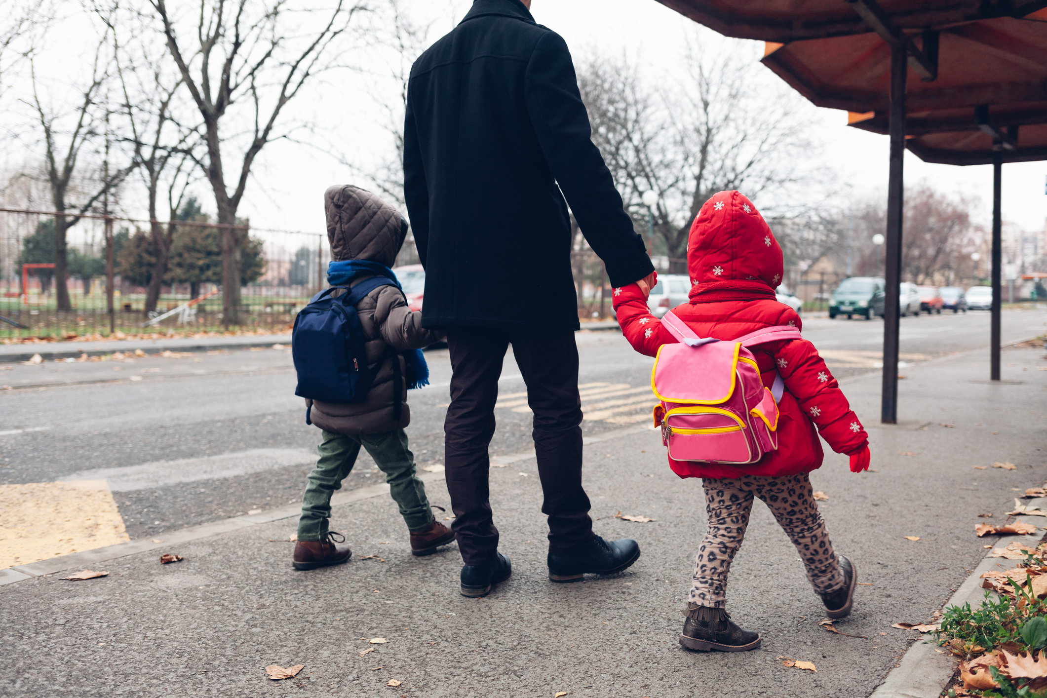 Dad with kids going to the bus stop