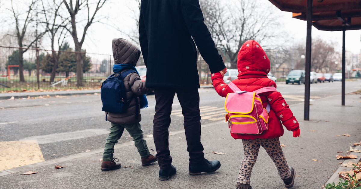 Dad with kids going to the bus stop