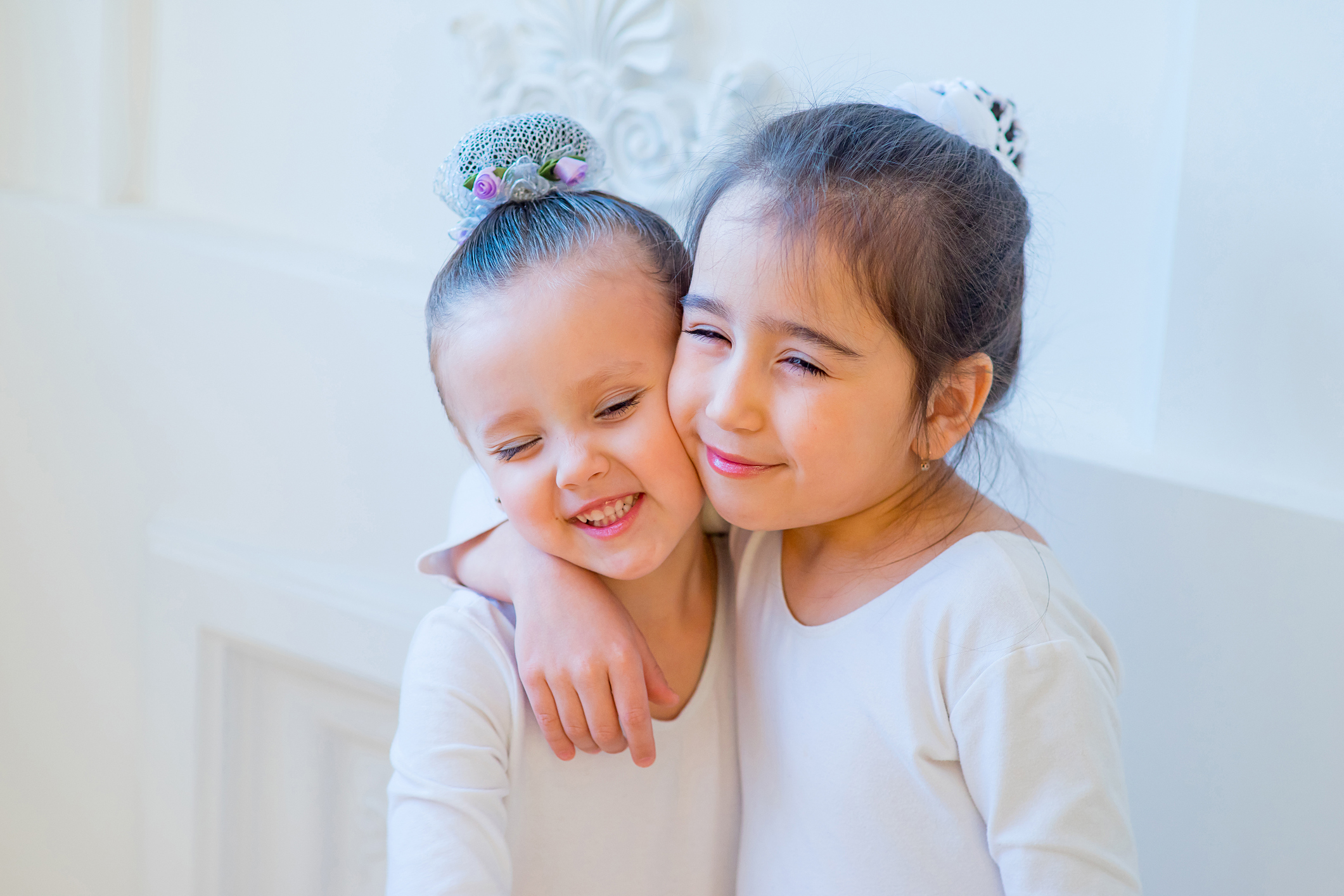 Two young ballet dancers hug