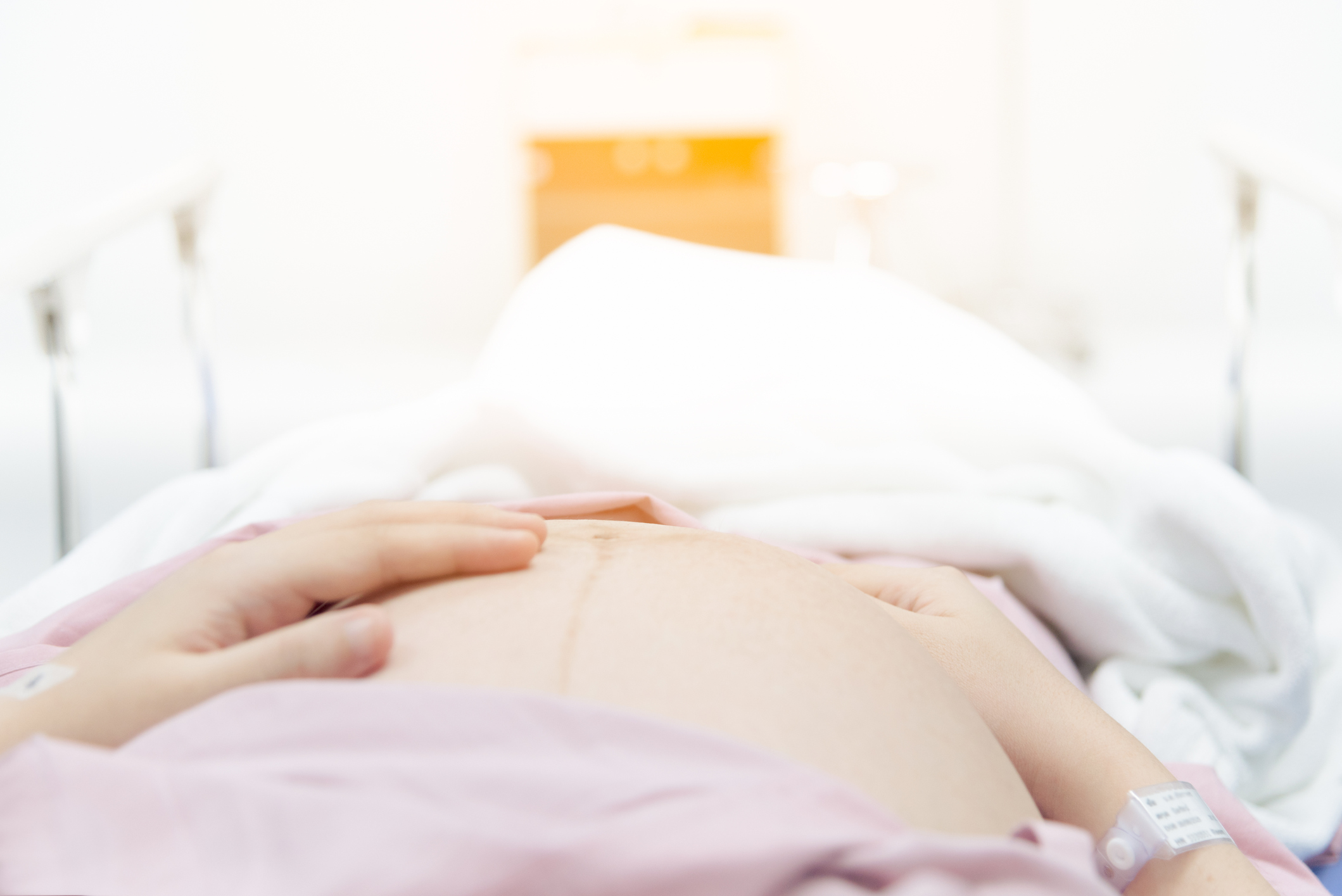 Close up of pregnant woman in delivery room with light brightly