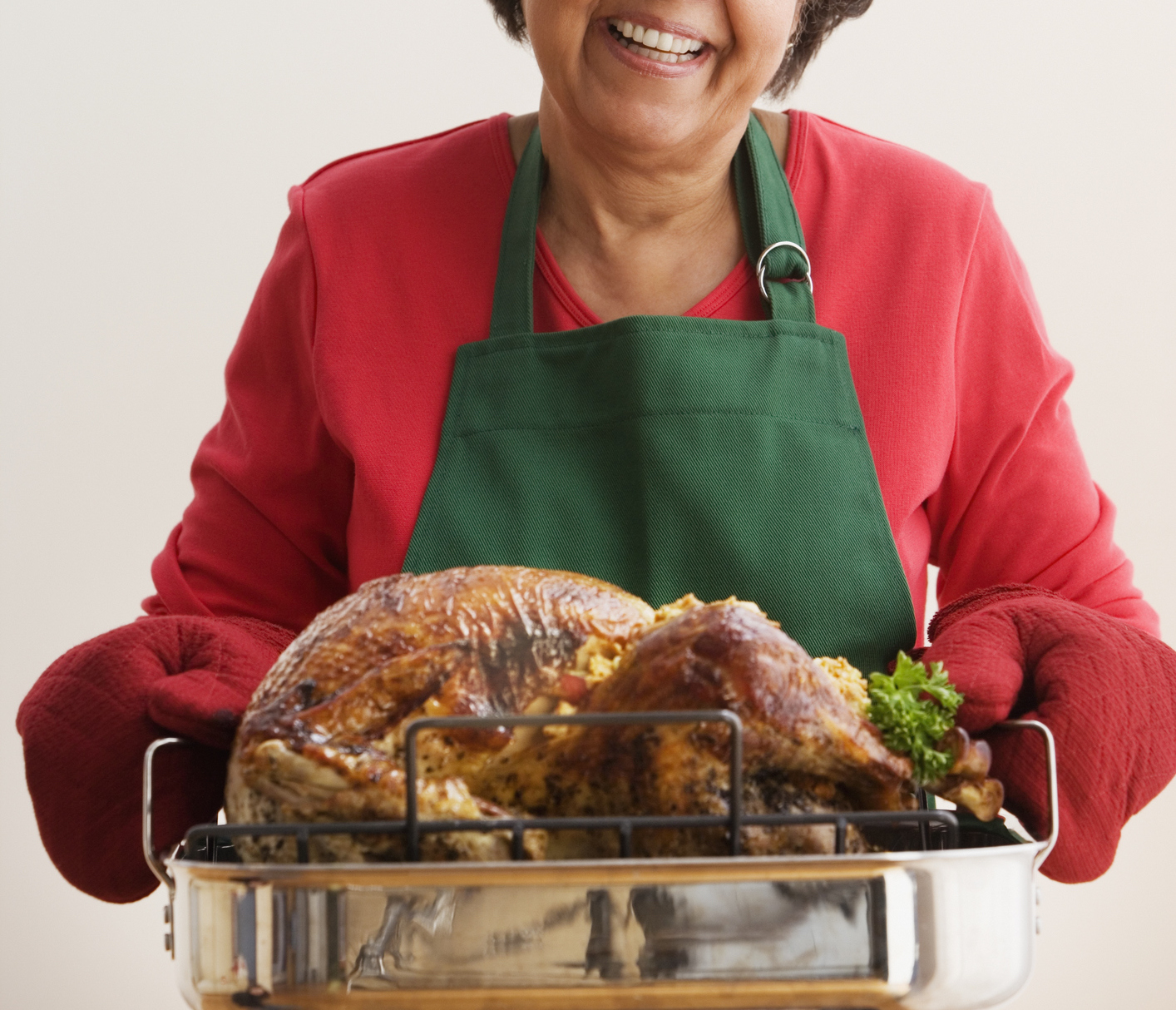 Senior Hispanic woman holding roasted turkey