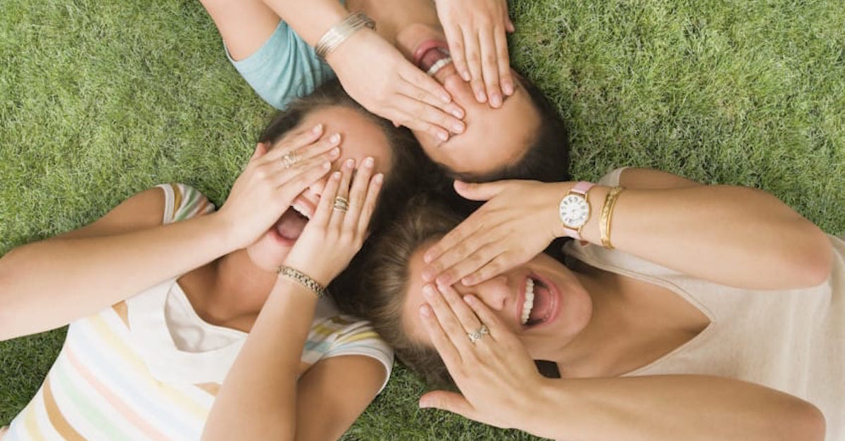 Multi-ethnic girls laying on grass