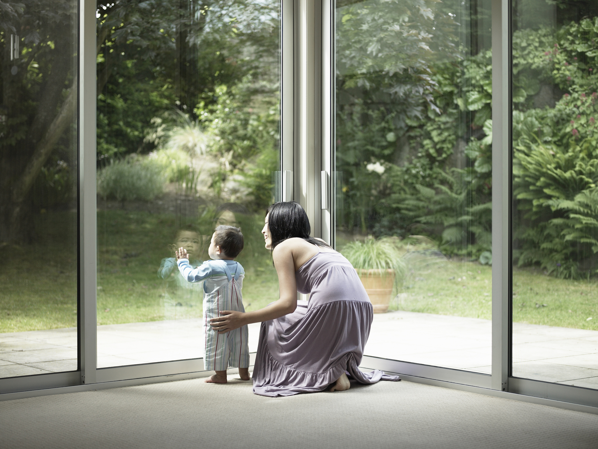 Mother and son looking out window