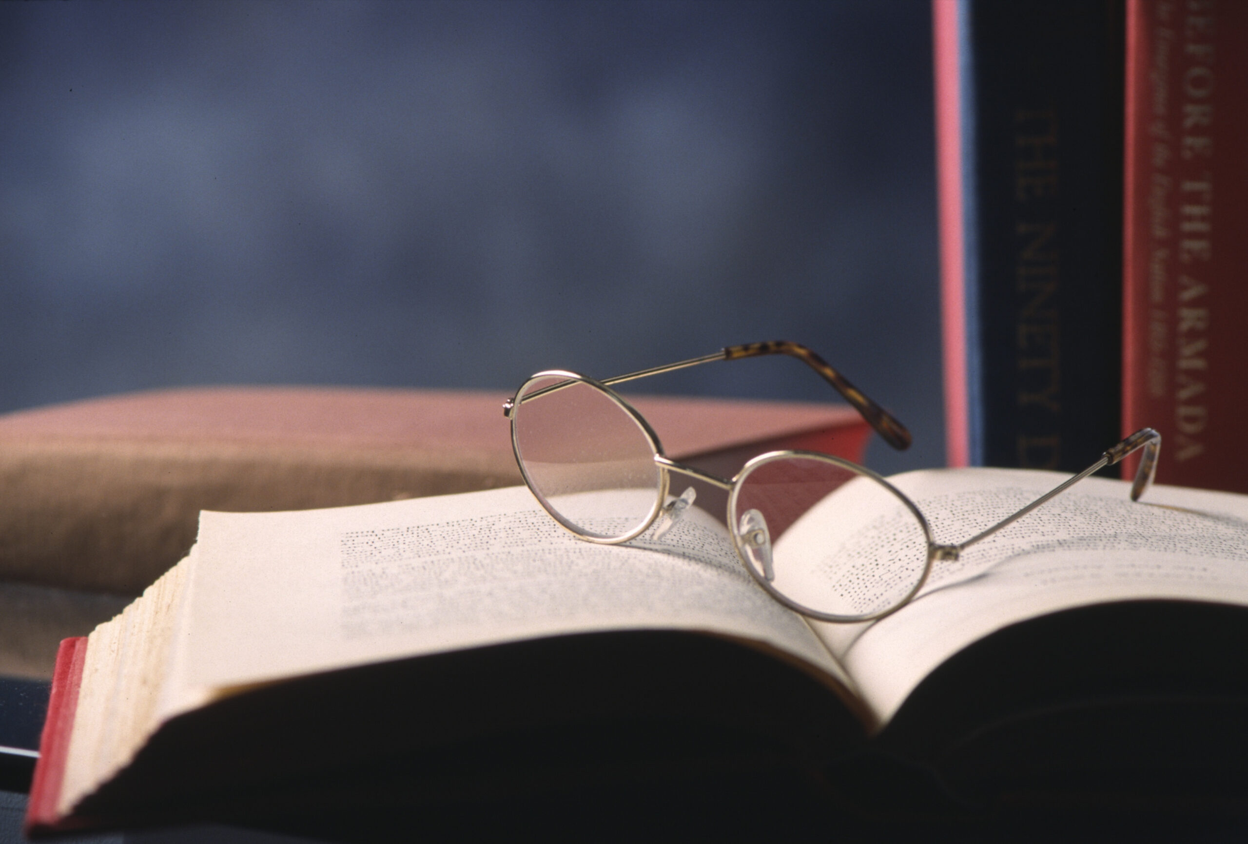 Still life of spectacles on open book in study