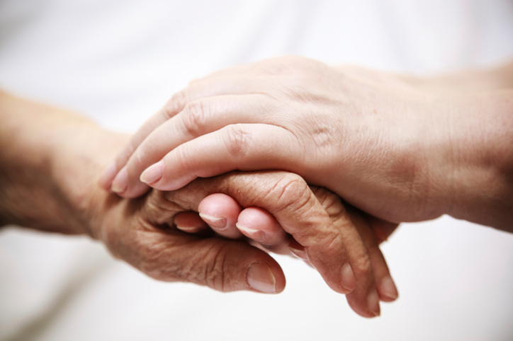 adult helping senior in hospital