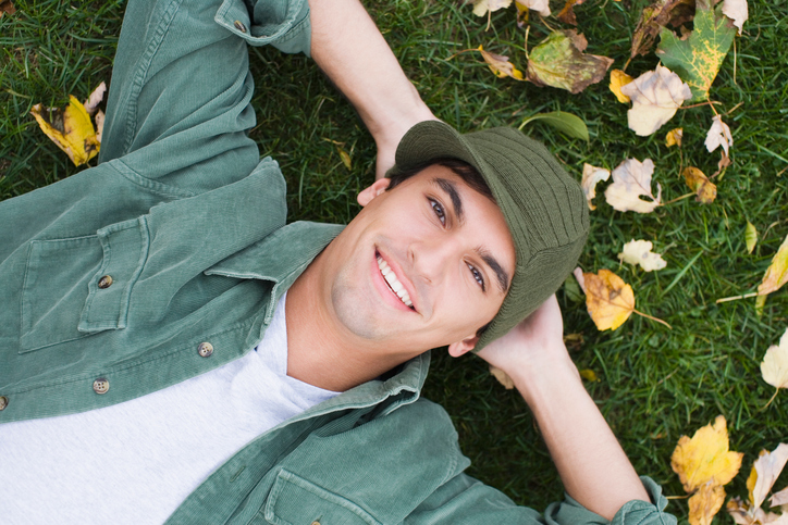 Close-up of a man lying on grass and smiling