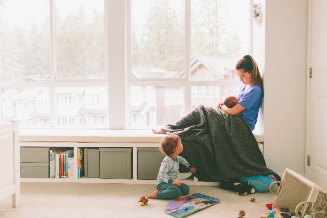 a-little-boy-playing-on-the-floor-while-his-mother-feeds-his-baby-sister_t20_yw8PbO.jpg