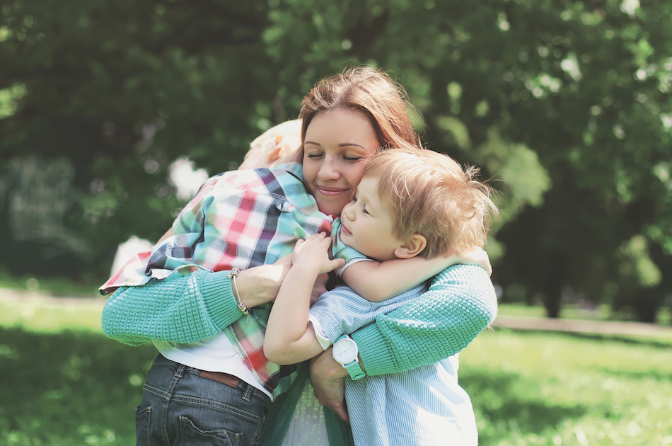 Family happiness! Happy mother tenderly embracing his two sons i