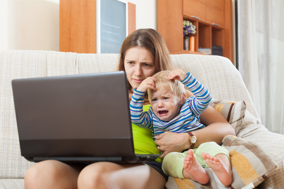 sorehead mother with crying baby working online