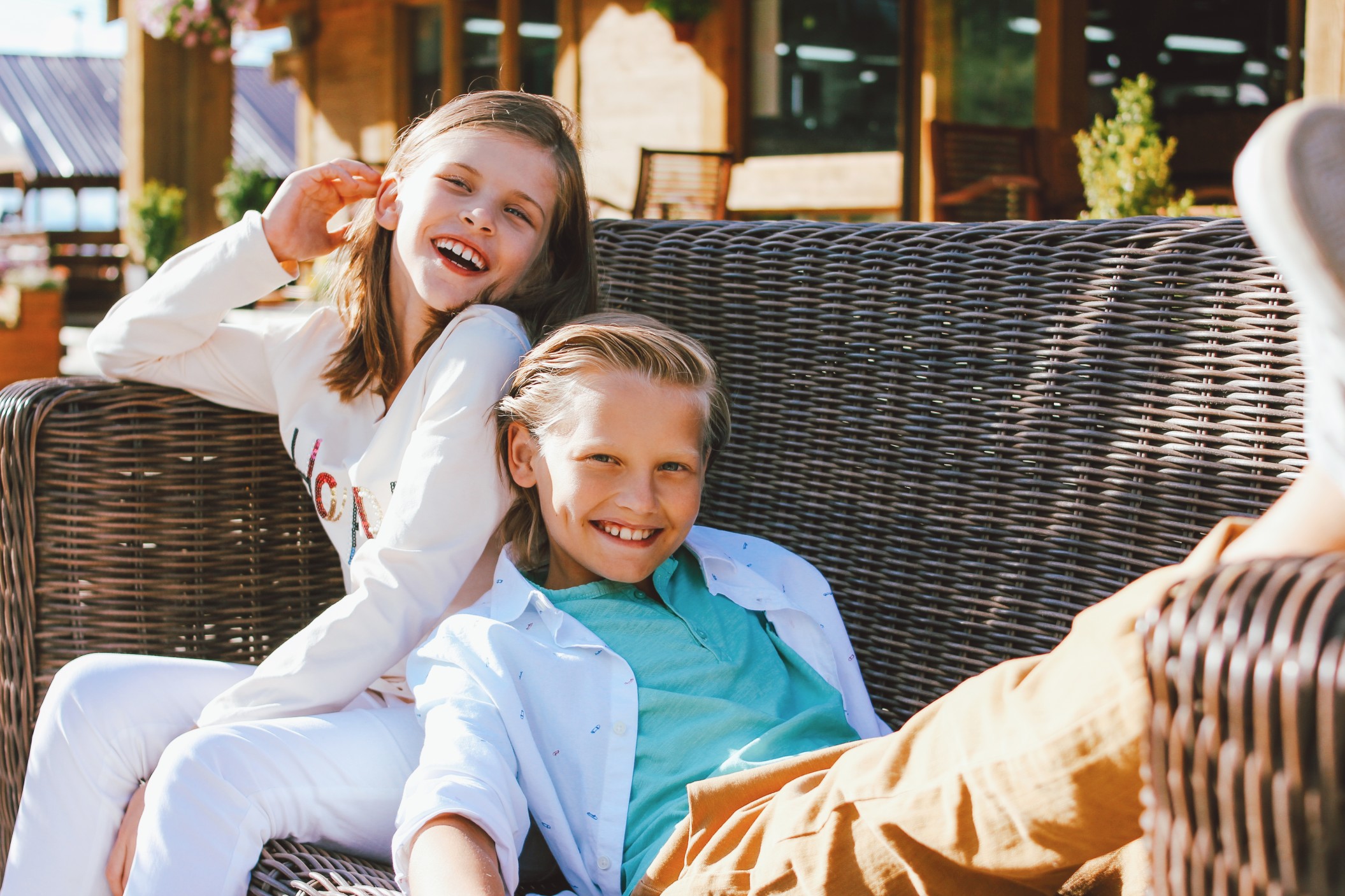 attractive-preteen-happy-children-sister-and-brother-friends-sitting-on-wicker-sofa-in-backyard-of_t20_xRK00B.jpg