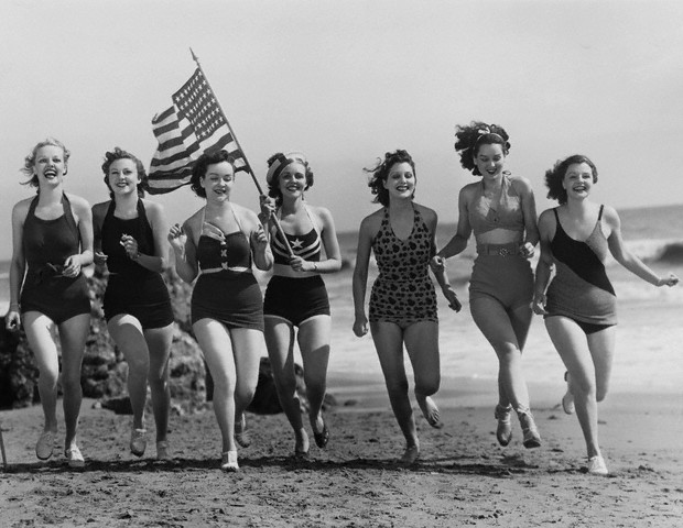 Actresses Carrying Flag on Beach