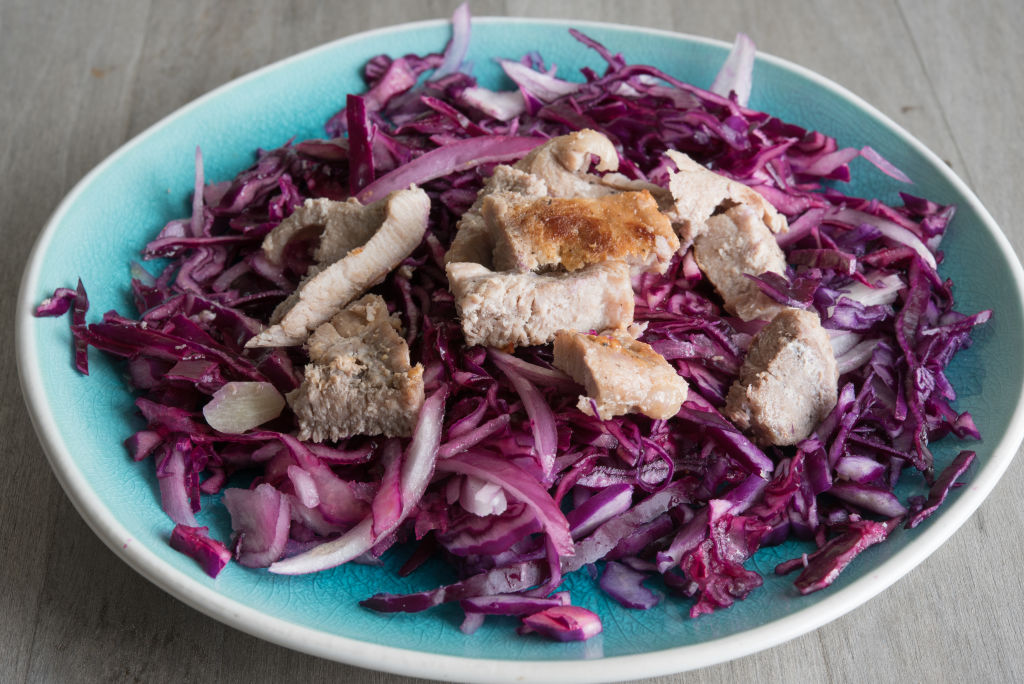 Healthy eating: red cabbage salad topped with lean pork meat