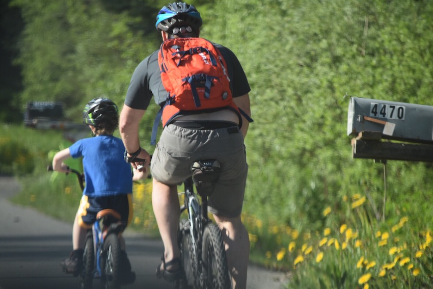 father-and-son-biking-in-sunshine-outside-juneau-alaska-on-beautiful-spring-day_t20_JavaOw.jpg