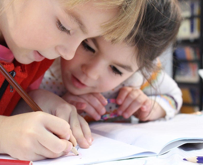 girls-on-desk-looking-at-notebook-1598231.jpg