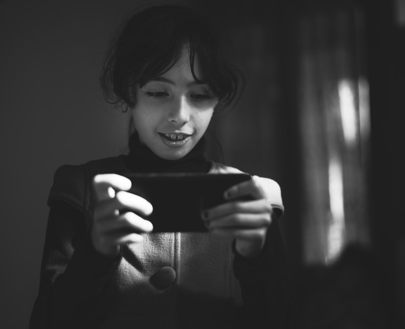 grayscale-photography-of-girl-using-smartphone-1701278.jpg