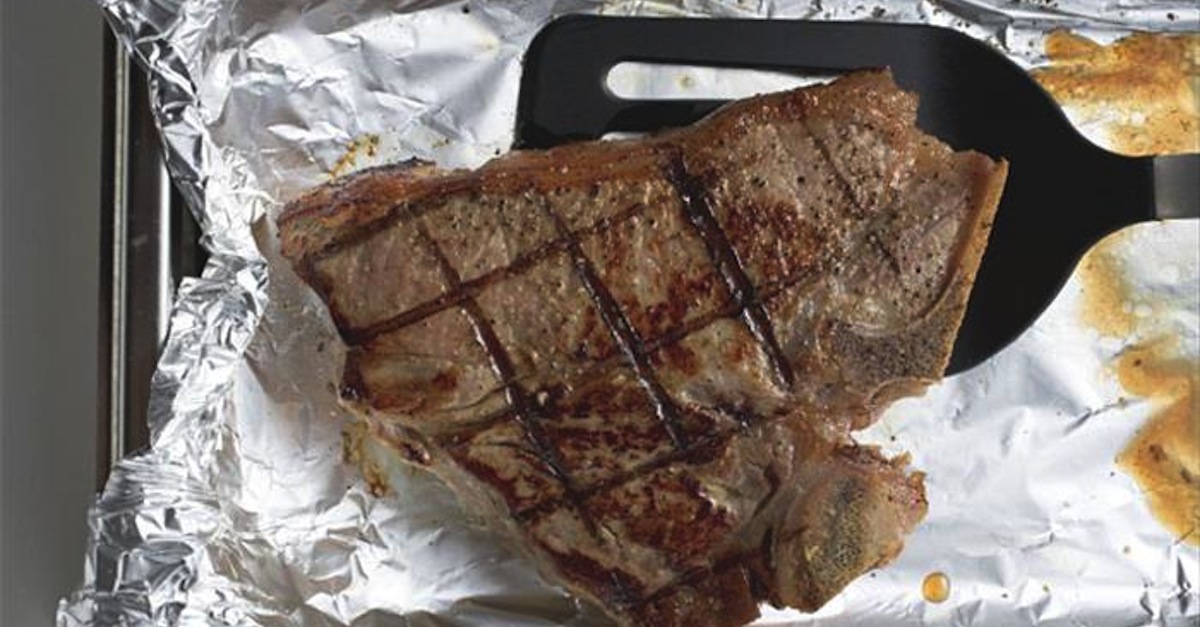 grilled_t-bone_steak_on_aluminium_foil_with_spatula_958407