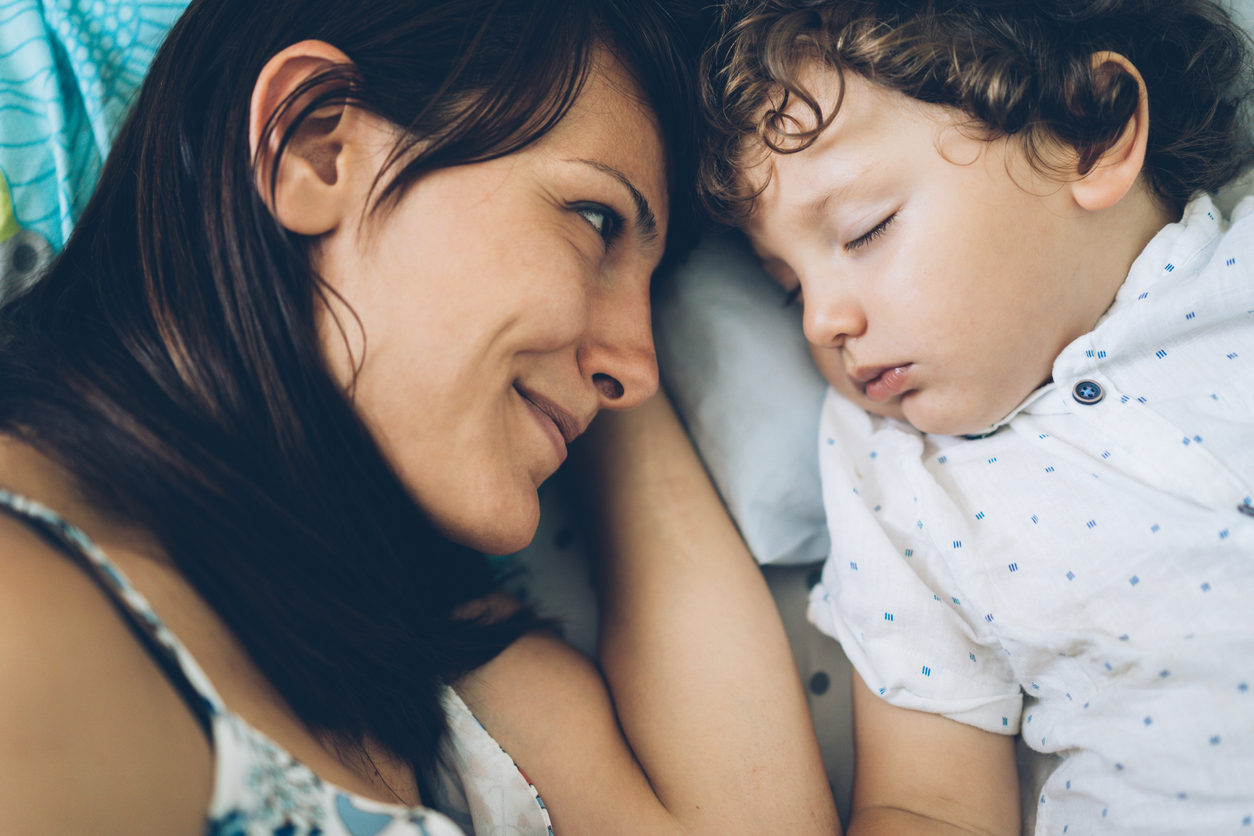 Mother looking at her cute son sleeping