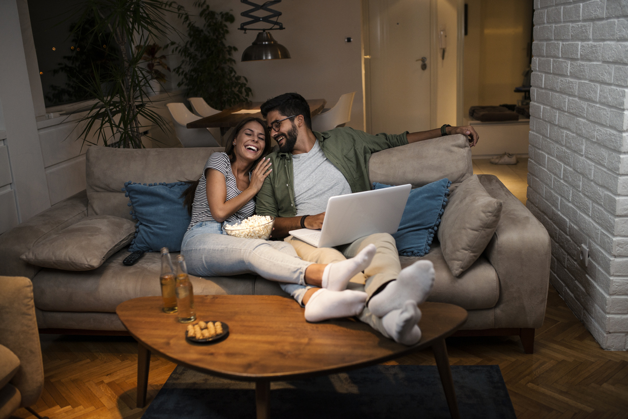 Young couple watching a movie on a laptop.