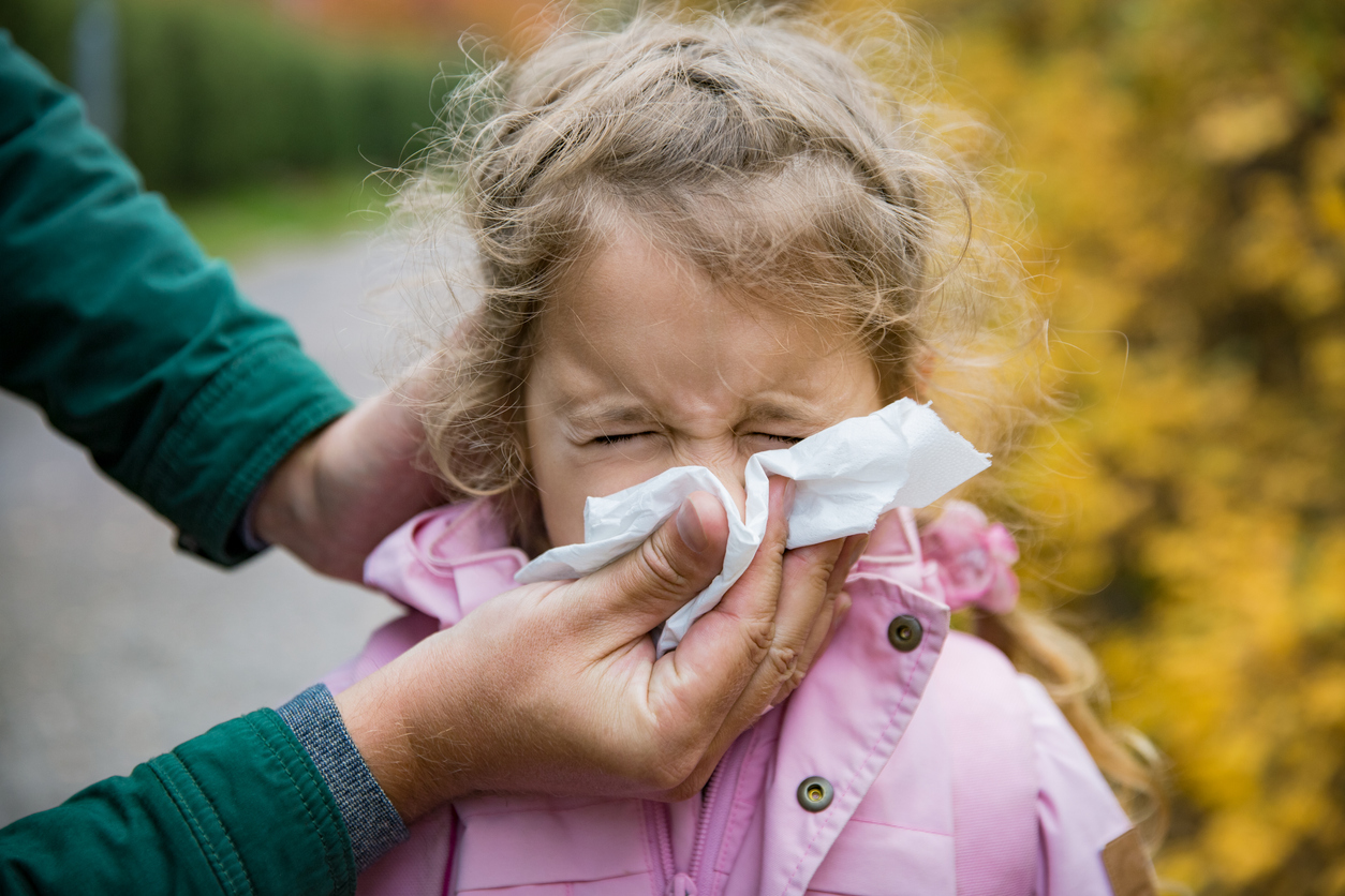 Father wiping daughter's nose with handkerchief