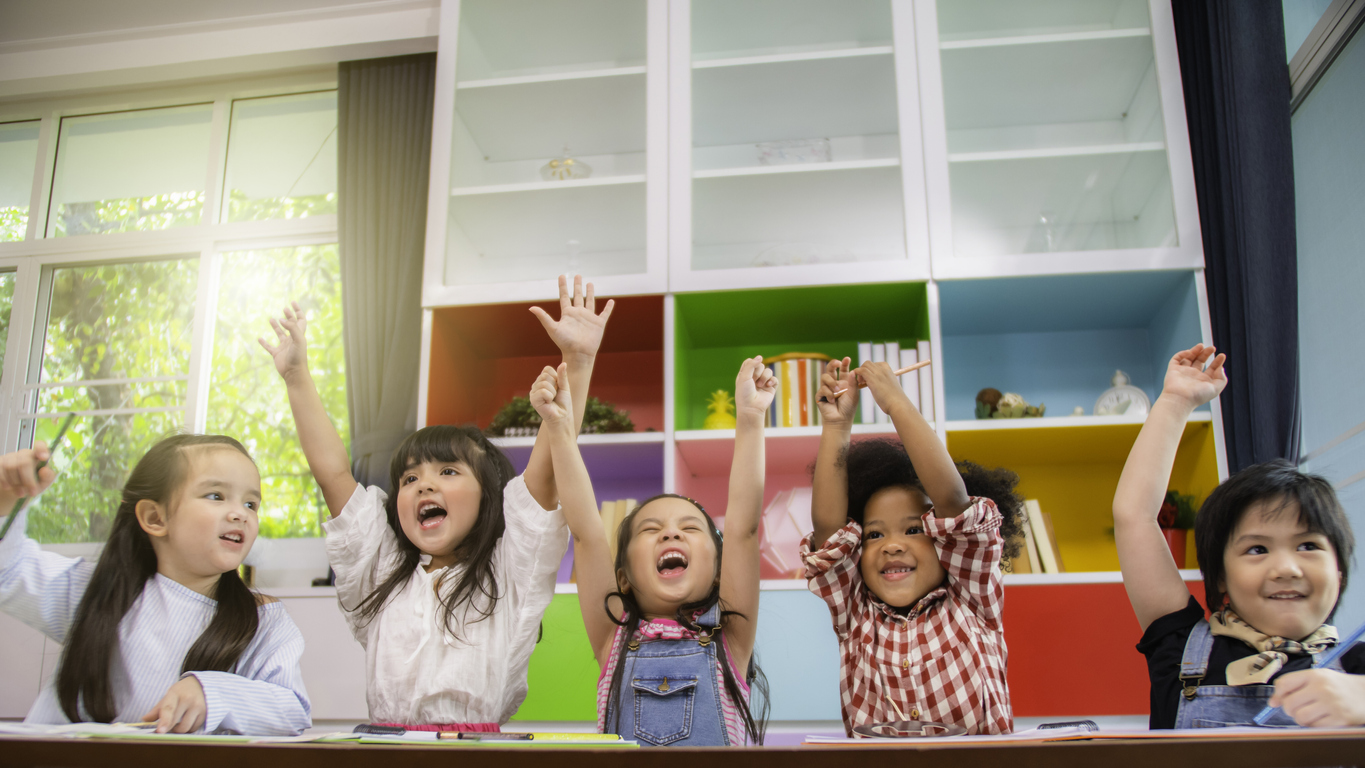 Group of multi-ethnic five little kids children African American, asian and Caucasian happiness together with friend to draw colour pencil to full colour of picture in living room or class room