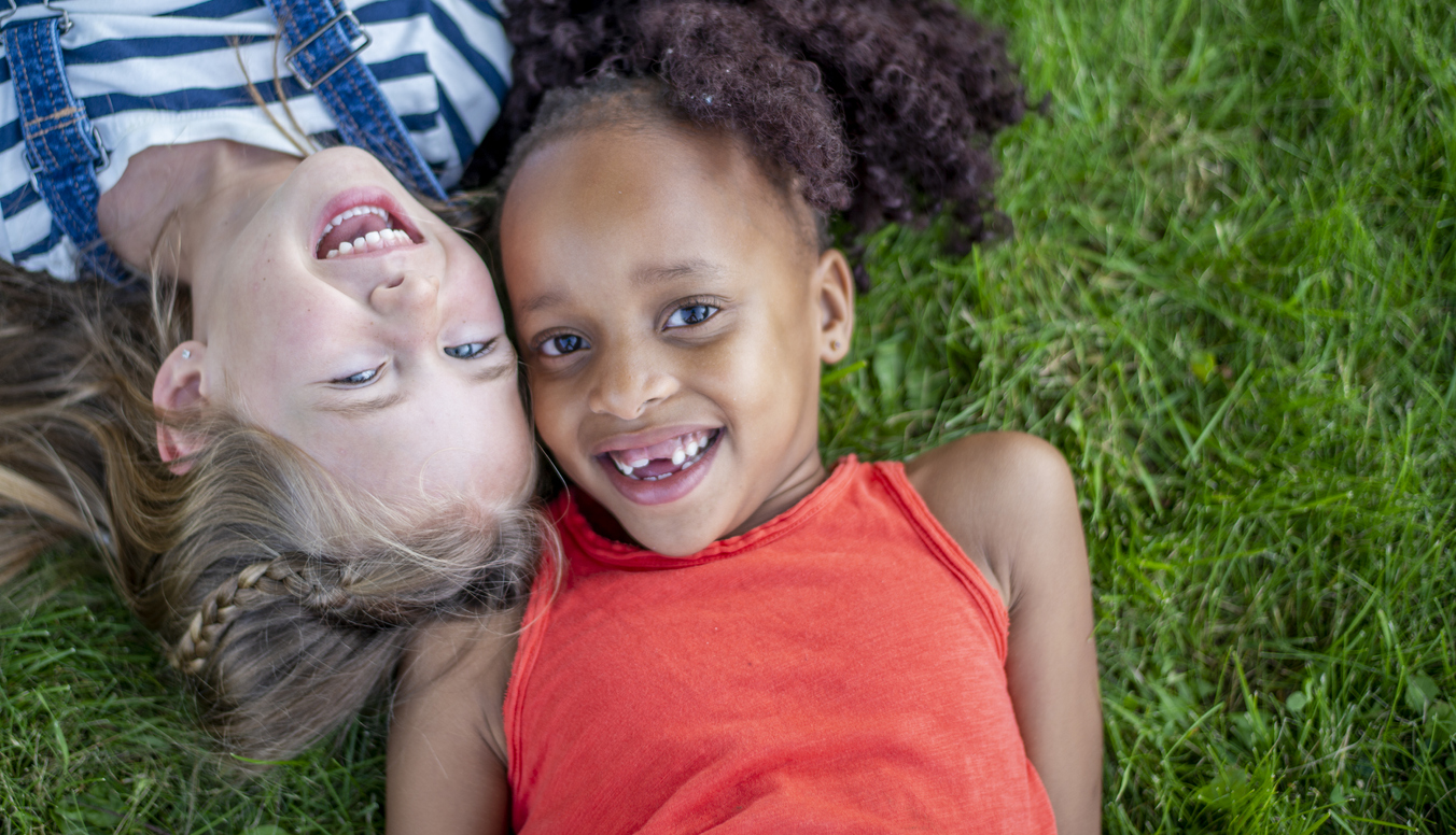 Two girls lying on the grass in a park