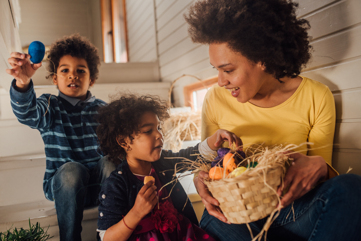 Woman showing children basket of Easter eggs