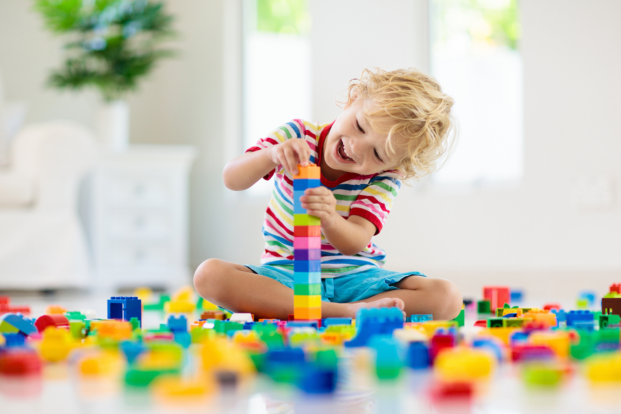 Child playing with toy blocks. Toys for kids.