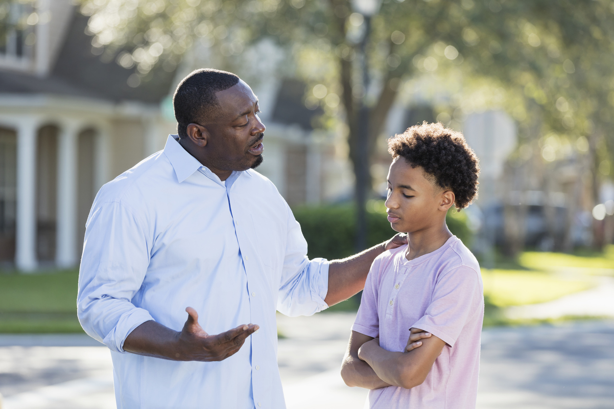 Father disciplining or giving advice to teenage boy