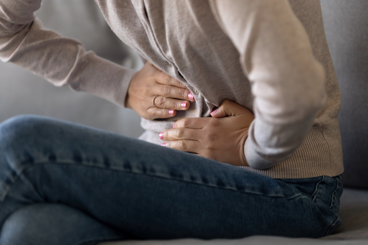 Cropped closeup image female touching stomach suffering from severe ache