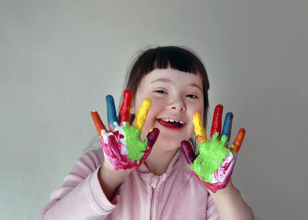 Cute little girl with painted hands. Isolated on grey background.