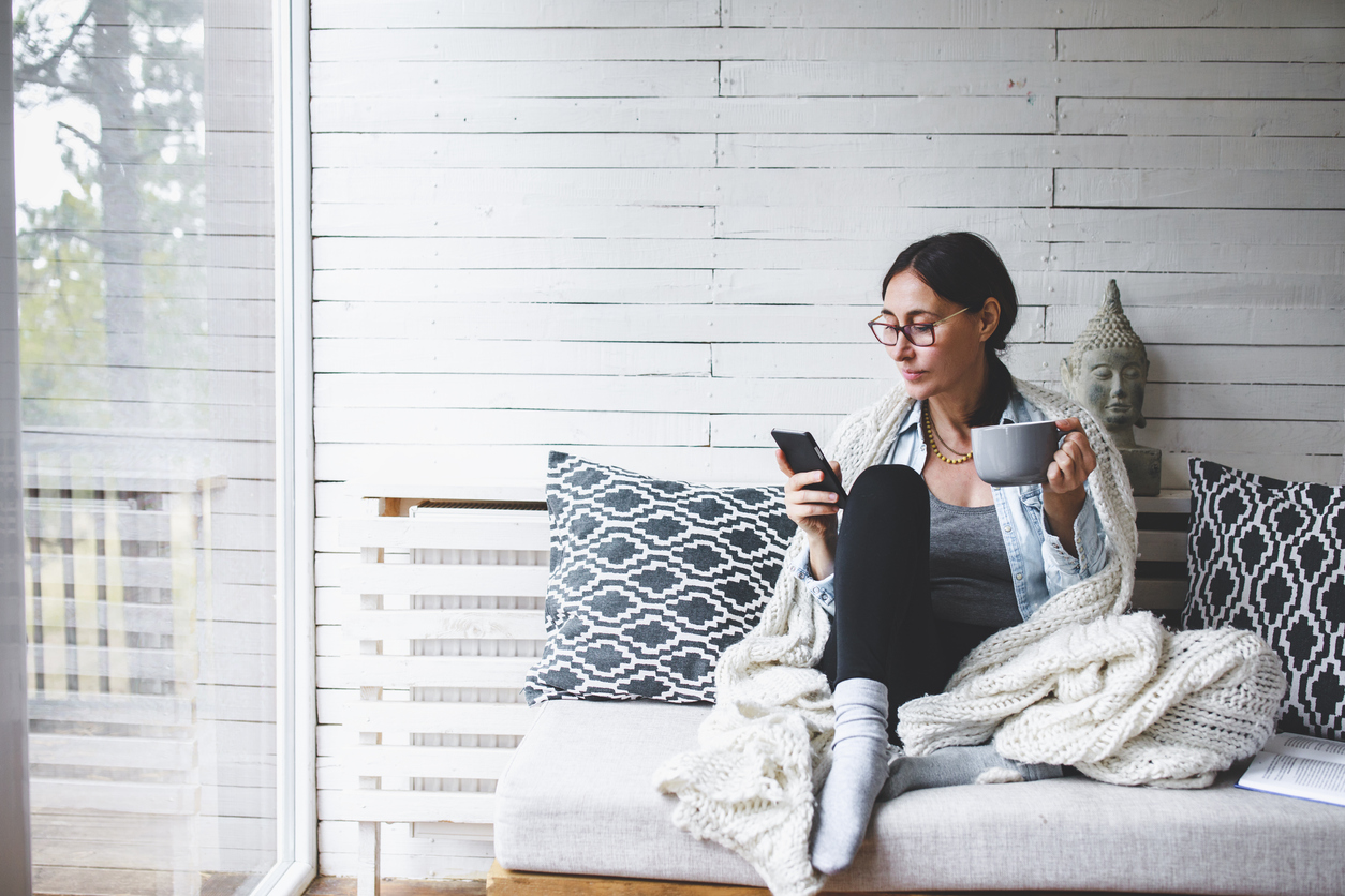 Middle-aged woman siting comfortable and enjoys tea