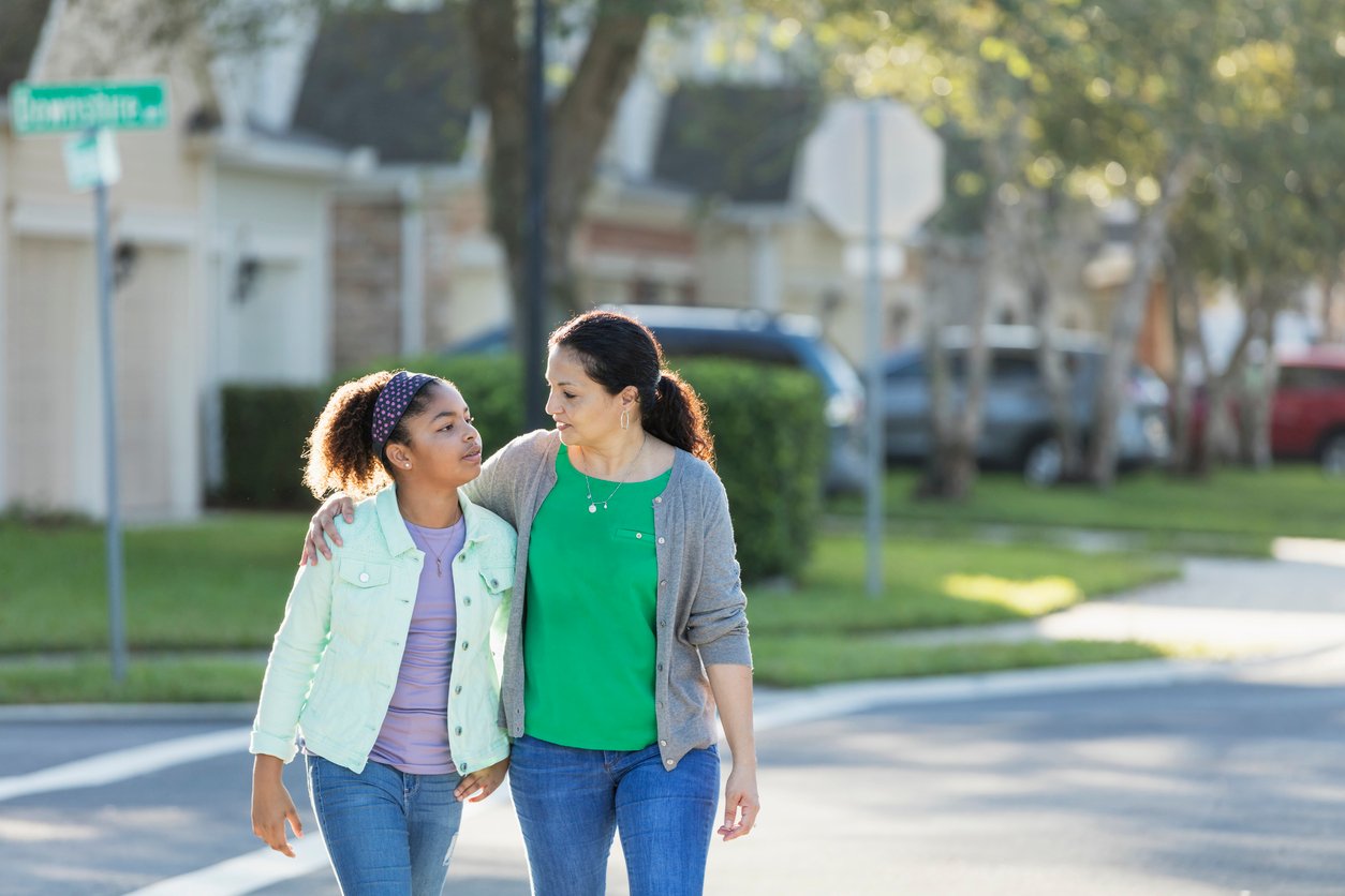 Mother and daughter walking together, talking