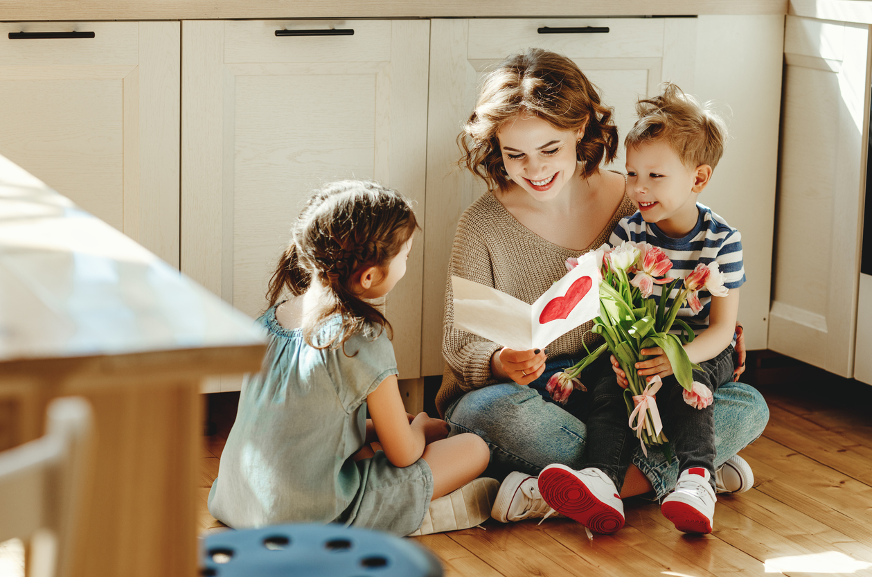 Happy mother getting gifts from kids at home