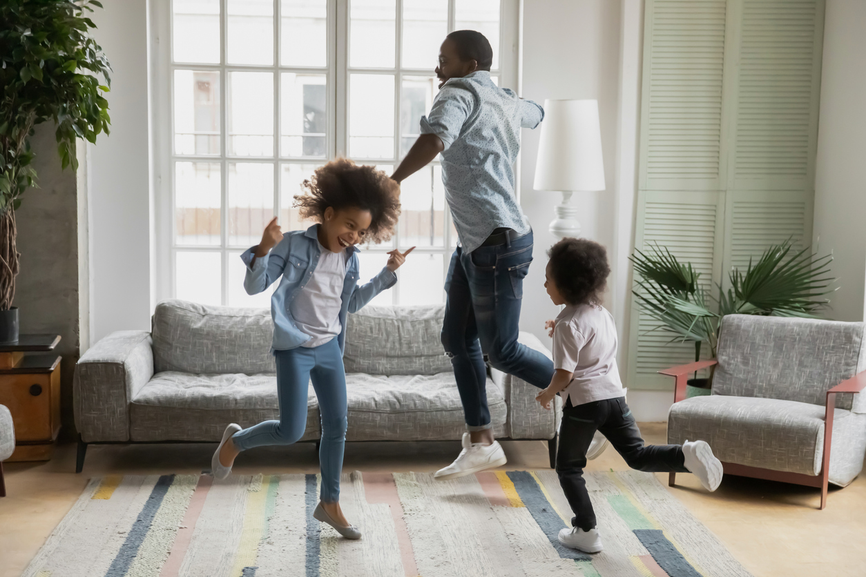 African father son and daughter listening music dancing at home