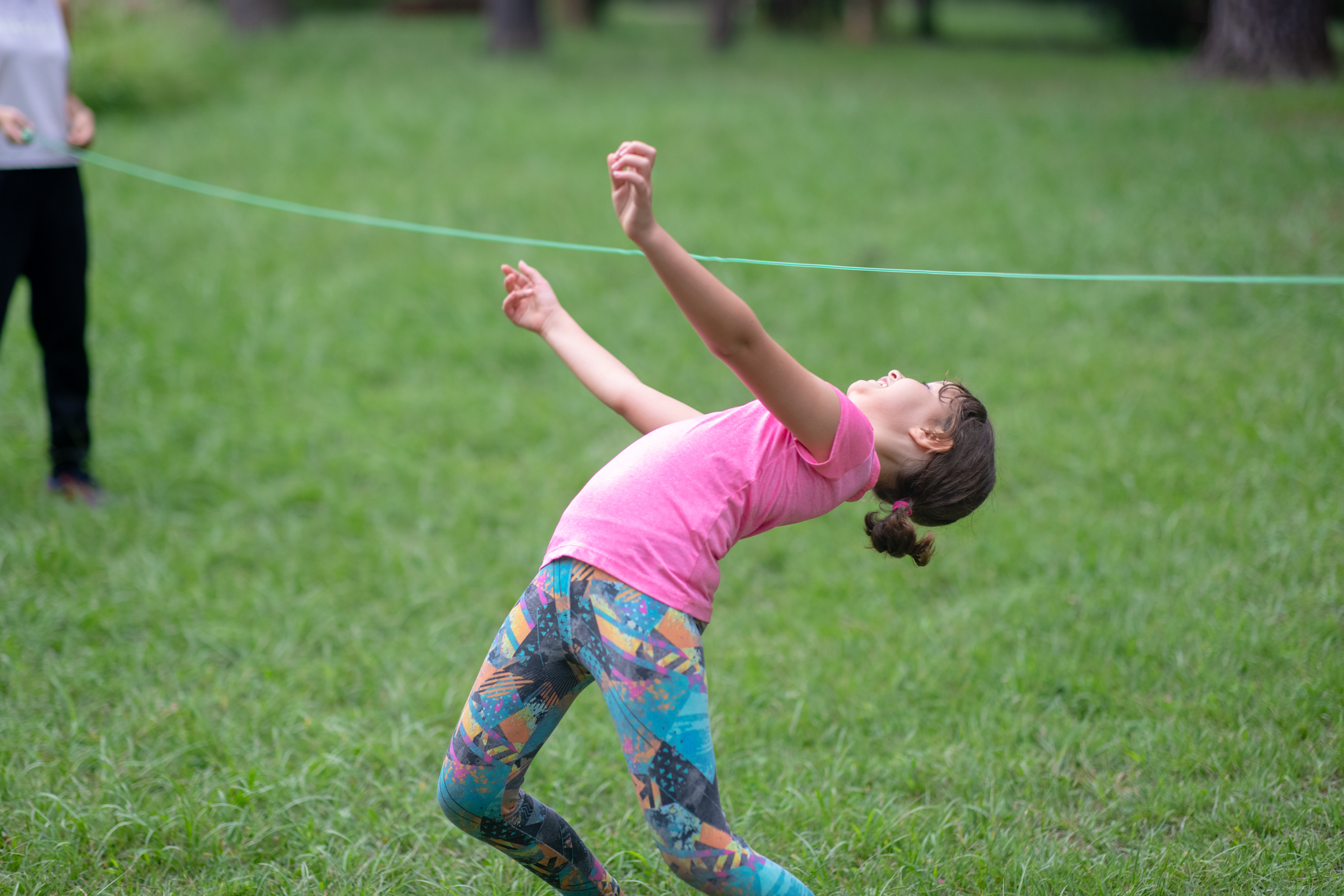 Little girl walking through under the rope like Limbo dance